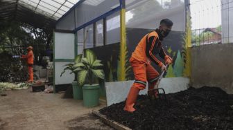 Petugas penanganan prasarana dan sarana umum (PPSU) mengaduk pupuk kompos di Tempat Pengolahan Sampah Terpadu Grogol Selatan, Kebayoran Lama, Jakarta, Kamis (4/11/2021). [Suara.com/Angga Budhiyanto]