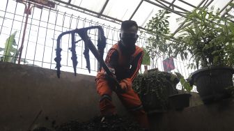 Petugas penanganan prasarana dan sarana umum (PPSU) mengaduk pupuk kompos di Tempat Pengolahan Sampah Terpadu Grogol Selatan, Kebayoran Lama, Jakarta, Kamis (4/11/2021). [Suara.com/Angga Budhiyanto]