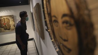 Pengunjung mengamati lukisan yang ditampilkan dalam pameran bertajuk &quot;Hai, Kamu!&quot;, di Balai Budaya, Jakarta, Kamis (4/11/2021). [Suara.com/Angga Budhiyanto]