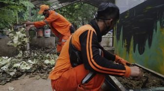 Petugas penanganan prasarana dan sarana umum (PPSU) mencampur sampah organik untuk diolah menjadi pupuk kompos di Tempat Pengolahan Sampah Terpadu Grogol Selatan, Kebayoran Lama, Jakarta, Kamis (4/11/2021). [Suara.com/Angga Budhiyanto]