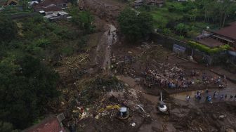 Foto udara Tim SAR gabungan bersama relawan dan warga membersihkan endapan lumpur saat pencarian korban akibat banjir bandang di Bulukerto, Kota Batu, Jawa Timur, Jumat (5/11/2021).  ANTARA FOTO/Zabur Karuru