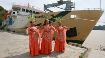 Tiga penari berfoto di dekat KM Sabuk Nusantara 76 di Pelabuhan Gorontalo, Kota Gorontalo, Gorontalo, Jumat (5/11/2021). ANTARA FOTO/Adiwinata Solihin