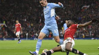 Bek Manchester United Aaron Wan-Bissaka (kanan) menantang gelandang Manchester City Phil Foden selama pertandingan sepak bola Liga Premier Inggris antara Manchester United dan Manchester City di Old Trafford, Manchester, Inggris, Sabtu (6/11/2021). [OLI SCARFF / AFP]