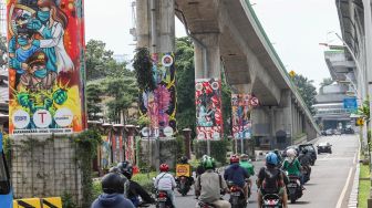 Kendaraan melintasi Jalan Layang Non Tol Transjakarta (JLNT) yang dihiasi mural di Jalan Trunojoyo, Jakarta Selatan, Sabtu (6/11/2021). [Suara.com/Alfian Winanto]