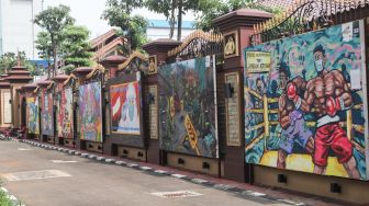 Kendaraan melintas di depan mural yang berisi kritik terhadap Polri di Jalan Trunojoyo, Jakarta Selatan, Sabtu (6/11/2021). [Suara.com/Alfian Winanto]