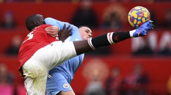 Bek Manchester United Eric Bailly (kiri) bersaing dengan gelandang Manchester City Phil Foden selama pertandingan sepak bola Liga Premier Inggris antara Manchester United dan Manchester City di Old Trafford, Manchester, Inggris, Sabtu (6/11/2021). [OLI SCARFF / AFP]