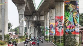 Kendaraan melintasi Jalan Layang Non Tol Transjakarta (JLNT) yang dihiasi mural di Jalan Trunojoyo, Jakarta Selatan, Sabtu (6/11/2021). [Suara.com/Alfian Winanto]