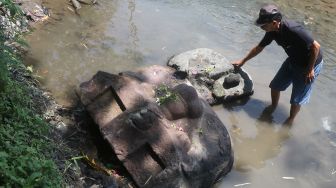 Warga mengamati kepala arca Kala yang ditemukan di aliran sungai Desa Nambaan, Kediri, Jawa Timur, Sabtu (6/11/2021).  ANTARA FOTO/Prasetia Fauzani
