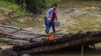 Warga melintasi jembatan darurat di Desa Murung B, Kecamatan Hantakan, Kalimantan Selatan, Senin (8/11/2021). [ANTARA FOTO/Bayu Pratama S]