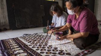 Pekerja menyelesaikan pembuatan kain batik cap khas Palembang di rumah produksi Eka Marlina di Palembang, Sumatera Selatan, Senin (8/11/2021). [ANTARA FOTO/Nova Wahyudi]
