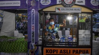 Peserta menawarkan kopi asli Papua saat Festival Peparnas Papua yang digelar di Kompleks Stadion Lukas Enembe, Kabupaten Jayapura, Papua, Senin (8/11/2021). [ANTARA FOTO/Raisan Al Farisi]