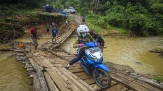 Pengendara motor tergelincir saat melintasi jembatan darurat di Desa Murung B, Kecamatan Hantakan, Kalimantan Selatan, Senin (8/11/2021). [ANTARA FOTO/Bayu Pratama S]