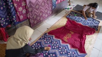 Pekerja menyelesaikan pembuatan kain jumputan di rumah produksi Eka Marlina di Palembang, Sumatera Selatan, Senin (8/11/2021). [ANTARA FOTO/Nova Wahyudi]