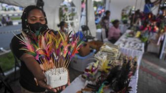 Peserta menunjukan barang kerajinan yang dijualnya saat Festival Peparnas Papua di Kompleks Stadion Lukas Enembe, Kabupaten Jayapura, Papua, Senin (8/11/2021). [ANTARA FOTO/Raisan Al Farisi]