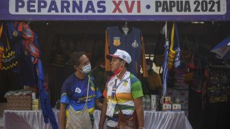 Panitia berbincang di depan salah satu tenda peserta Festival Peparnas Papua yang digelar di Kompleks Stadion Lukas Enembe, Kabupaten Jayapura, Papua, Senin (8/11/2021). [ANTARA FOTO/Raisan Al Farisi]