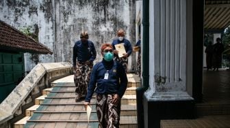 Abdi dalem Keraton Yogyakarta keluar membawa "serat kekancingan" atau surat keputusan seusai wisuda abdi dalem di Bangsal Kesatriyan, Keraton Yogyakarta, DI Yogyakarta, Selasa (9/11/2021). ANTARA FOTO/Hendra Nurdiyansyah