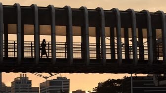 Pekerja melintas di JPO Polda Metro Jaya saat jam pulang kerja di Jakarta, Senin (8/11/2021). ANTARA FOTO/Indrianto Eko Suwarso