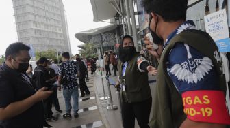 Satgas COVID-19 dalam pameran otomotif GAIKINDO Indonesia International Auto Show (GIIAS) 2021 mengimbau kepada pengunjung untuk memindai kode batang dari aplikasi PeduliLindungi sebelum memasuki area pameran di Indonesia Convention Exhibition (ICE) BSD, Serpong, Tangerang, Banten, Kamis (11/11/2021). [Suara.com/Angga Budhiyanto]