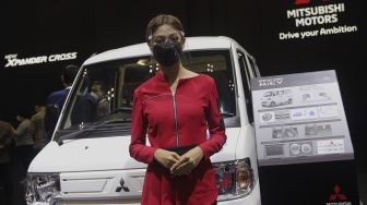Model berpose di depan kendaraan yang dipamerkan dalam pameran otomotif GAIKINDO Indonesia International Auto Show (GIIAS) 2021 di Indonesia Convention Exhibition (ICE) BSD, Serpong, Tangerang, Banten, Kamis (11/11/2021). [Suara.com/Angga Budhiyanto]