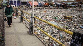 Warga berjalan di samping sampah yang menumpuk di Kali Dadap yang dipenuhi sampah di Kosambi, Kabupaten Tangerang, Banten, Jumat (12/11/2021). ANTARA FOTO/Fauzan