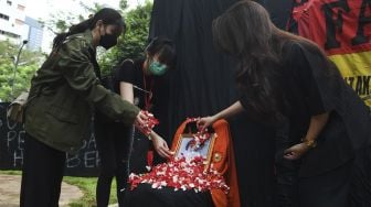 Mahasiswa Universitas Atma Jaya melakukan tabur bunga saat menggelar peringatan 23 tahun Tragedi Semanggi di Kampus Atma Jaya, Jakarta, Sabtu (13/11/2021). [ANTARA FOTO/Hafidz Mubarak A]