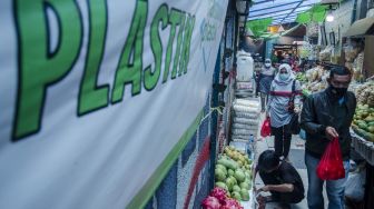 Warga membawa barang belanja menggunakan kantong plastik di Pasar Cihapit, Bandung, Jawa Barat, Minggu (14/11/2021). ANTARA FOTO/Novrian Arbi