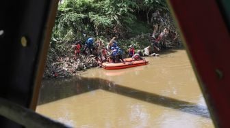 Anggota Forum Alumni Sispala DKI Jakarta (FASTA) berkolaborasi dengan Sekolah Sungai Jakarta (SSJ) dan Siswa Pencinta Alam (Sispala) membersihkan sungai di Bantaran Kali Ciliwung, Jakarta Selatan, Minggu (14/11/2021). [Suara.com/Alfian Winanto]