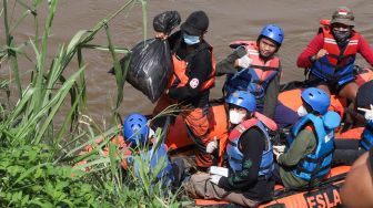 Anggota Forum Alumni Sispala DKI Jakarta (FASTA) berkolaborasi dengan Sekolah Sungai Jakarta (SSJ) dan Siswa Pencinta Alam (Sispala) membersihkan sungai di Bantaran Kali Ciliwung, Jakarta Selatan, Minggu (14/11/2021). [Suara.com/Alfian Winanto]