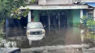 Sebuah mobil terendam banjir di halaman rumah penduduk di Tanjung Puri, Sintang, Kalimantan Barat, Minggu (14/11/2021). ANTARA FOTO/Jane Elisabeth Wuysang