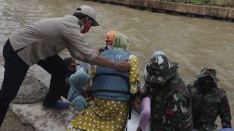 Petugas gabungan mengevakuasi korban menggunakan perahu karet saat simulasi penanganan banjir di Kalimalang, Cipinang Melayu, Jakarta, Rabu (17/11/2021). [Suara.com/Angga Budhiyanto]