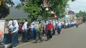 Sambut Kedatangan Presiden, Pelajar dan Emak-emak Berbaris di Jalan Sambil Pegang Bendera