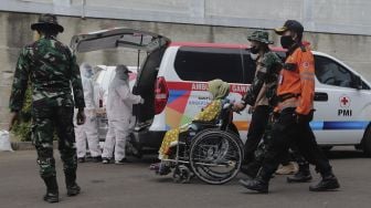 Petugas gabungan mengevakuasi korban saat simulasi penanganan banjir di halaman Universitas Borobudur, Kalimalang, Cipinang Melayu, Jakarta, Rabu (17/11/2021). [Suara.com/Angga Budhiyanto]