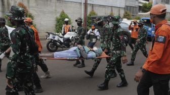 Petugas gabungan mengevakuasi korban saat simulasi penanganan banjir di halaman Universitas Borobudur, Kalimalang, Cipinang Melayu, Jakarta, Rabu (17/11/2021). [Suara.com/Angga Budhiyanto]