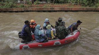 Petugas gabungan mengevakuasi korban menggunakan perahu karet saat simulasi penanganan banjir di Kalimalang, Cipinang Melayu, Jakarta, Rabu (17/11/2021). [Suara.com/Angga Budhiyanto]