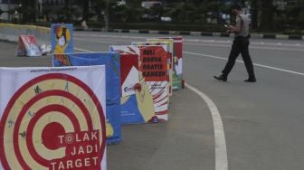 Deretan mural Hari Kesehatan Nasional berada di kawasan Patung Arjuna Wiwaha, Jakarta, Rabu (17/11/2021). [Suara.com/Angga Budiyanto]