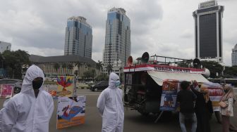 Polisi berhazmat berjaga saat unjuk rasa yang digelar oleh Koalisi Masyarakat Peduli Kesehatan (KOMPAK) di kawasan Patung Arjuna Wiwaha, Jakarta, Rabu (17/11/2021). [Suara.com/Angga Budiyanto]