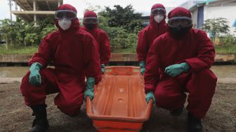 Petugas Suku Dinas Penanggulangan Kebakaran dan Penyelamatan (Gulkarmat) bersiap untuk mengevakuasi korban saat simulasi penanganan banjir di Kalimalang, Cipinang Melayu, Jakarta, Rabu (17/11/2021). [Suara.com/Angga Budhiyanto]