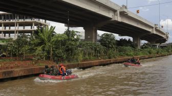 Petugas gabungan menggunakan perahu karet untuk mengevakuasi korban saat simulasi penanganan banjir di Kalimalang, Cipinang Melayu, Jakarta, Rabu (17/11/2021). [Suara.com/Angga Budhiyanto]