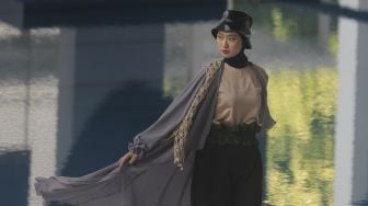 Model memperagakan busana muslim pada gelaran Jakarta Muslim Fashion Week (JMFW) di Stadion Aquatic, Gelora Bung Karno, Jakarta, Kamis (18/11/2021). [Suara.com/Angga Budhiyanto]