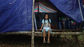 Seorang anak berada di tenda pengungsian di dalam hutan Desa Sungai Rambai, Kelurahan Mekar Jaya, Kabupaten Sintang, Kalimantan Barat, Rabu (17/11/2021). ANTARA FOTO/Jessica Helena Wuysang