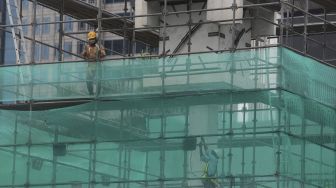 Pekerja memasang perancah saat akan melakukan pengerjaan relokasi tugu jam di Jalan MH. Thamrin, Jakarta, Jumat (19/11/2021). [Suara.com/Angga Budhiyanto]