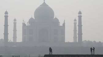 Warga mengunjungi kompleks Mehtab Bagh di belakang Taj Mahal saat kondisi kabut asap di Agra, India, pada (16/11/2021). [SAJJAD HUSSAIN / AFP]