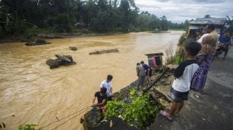 Sejumlah warga melihat salah satu jembatan darurat yang rusak akibat meluapnya sungai Hantakan di Kecamatan Hantakan, Kabupaten Hulu Sungai Tengah, Kalimantan Selatan, Jumat (19/11/2021). [ANTARA FOTO/Bayu Pratama S]