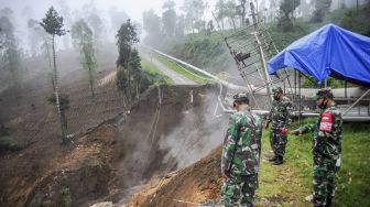 Sejumlah aparat TNI berjaga di sekitar lokasi tanah longsor yang memutus jalan utama di Kawasan Wisata Darajat Pass, Kabupaten Garut, Jawa Barat, Sabtu (20/11/2021). [ANTARA FOTO/Raisan Al Farisi]