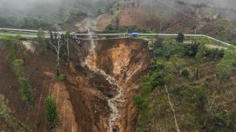 Foto udara di sekitar lokasi tanah longsor yang memutus jalan utama di Kawasan Wisata Darajat Pass, Kabupaten Garut, Jawa Barat, Sabtu (20/11/2021). [ANTARA FOTO/Raisan Al Farisi]