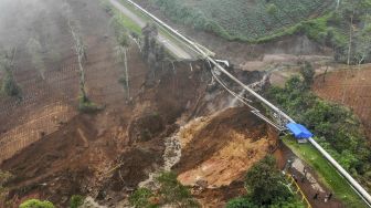Foto udara di sekitar lokasi tanah longsor yang memutus jalan utama di Kawasan Wisata Darajat Pass, Kabupaten Garut, Jawa Barat, Sabtu (20/11/2021). [ANTARA FOTO/Raisan Al Farisi]