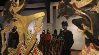 Pengunjung melihat koleksi wayang dalam pameran wayang bertema &#039;Wayang Rupa Kita&#039; di Bentara Budaya, Palmerah, Jakarta, Sabtu (20/11/2021). [Suara.com/Angga Budhiyanto]