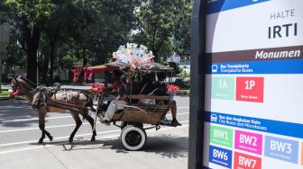 Warga berwisata dengan delman di Kawasan IRTI Monas, Jakarta Pusat, Minggu (21/11/2021). [Suara.com/Alfian Winanto]