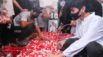 Keluarga berdoa diatas pusara mantan Atlet Bulutangkis Hj. Verawaty Fajrin usai dimakamkan di TPU Tanah Kusir, Jakarta Selatan, Minggu (21/11/2021). [Suara.com/Alfian Winanto]