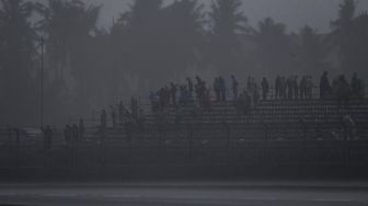 Penonton berada di atas tribun saat hujan deras menjelang race 2 WorldSBK seri Indonesia 2021 di Pertamina Mandalika International Street Circuit, Lombok Tengah, Nusa Tenggara Barat (NTB), Minggu (21/11/2021). ANTARA FOTO/Sigid Kurniawan
